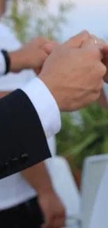 Close-up of a couple holding hands during a wedding dance session.