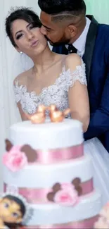 Bride and groom kissing by a wedding cake.