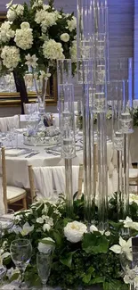 Elegant wedding table setting with white flowers and clear glass centerpieces.