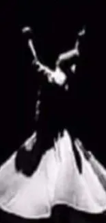 Whirling dervish in black-and-white silhouette against a dark background.