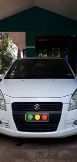 Front view of a white car parked in a green porch setting.