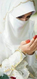 Woman wearing a white hijab, praying silently.