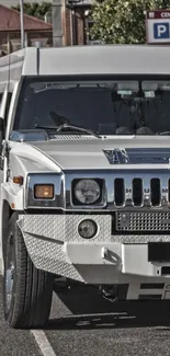 White Hummer limousine parked on a road, showcasing its luxury design.