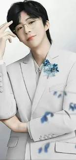 Young man in white suit with blue floral accents.