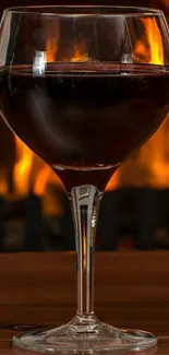 Wine glass in front of a warm fire background.