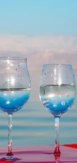 Elegant glasses reflecting a serene lake with a blue sky backdrop.