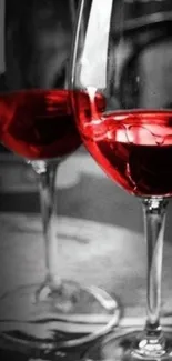 Two elegant wine glasses with red accents on a monochrome background.