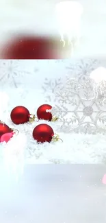 Red ornaments on snowy background with Christmas theme.