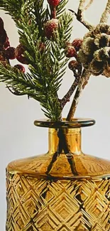 Golden vase with pine and berries arrangement.