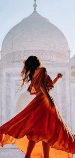 Woman in a crimson dress twirling gracefully with the Taj Mahal in the background.