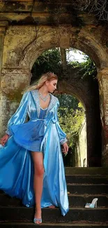 Woman in a stunning blue gown in a vintage archway setting.