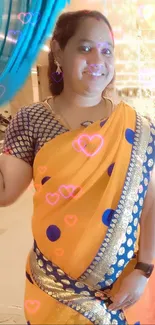 Woman in orange saree with blue dots and glowing hearts background.