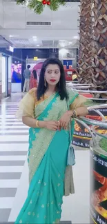 Woman wearing a green saree in a shopping mall.