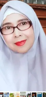 Portrait of a woman in a light gray hijab with glasses.