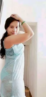 Elegant woman in light blue dress posing indoors.