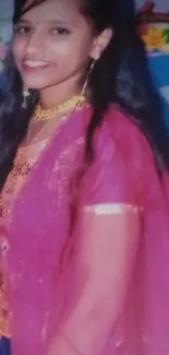 Woman in deep pink traditional attire with long hair and accessories.