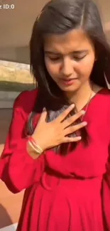 Woman in red dress in outdoor sunlight.