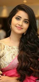 Elegant woman in soft pink saree with long flowing hair and graceful smile.