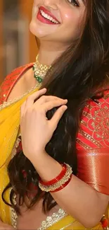 Woman in yellow saree with intricate red blouse