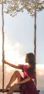 Woman in purple dress swinging at sunset.