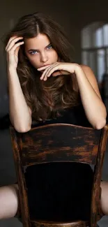 Stylish woman sitting on a chair in dark ambiance.