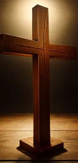 Wooden cross on a dark background glowing with light.