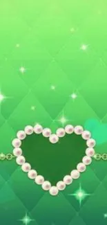 Emerald heart with pearls and sparkles on green background.