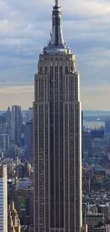 Empire State Building with New York skyline under blue sky.