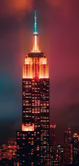 Empire State Building illuminated at night against a vibrant city skyline.