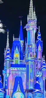 Illuminated enchanted castle at night, glowing in vibrant blue hues.