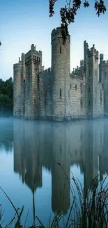 Serene castle reflection on a misty lake with surrounding trees.