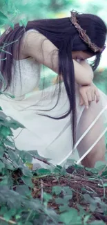 Girl with long hair in white dress sitting in a dreamy forest setting.