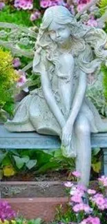 Enchanting garden fairy statue amidst vibrant flowers.