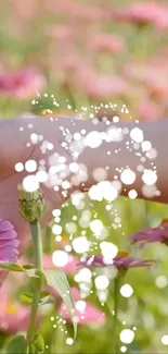 Hand reaching for flowers with magical sparkles.