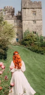 Woman in white dress walking toward a stone castle surrounded by lush greenery and flowers.