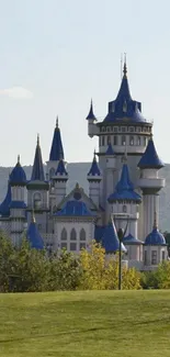 Enchanting fairytale castle with blue spires and green landscape.