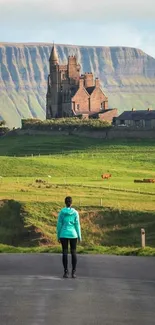 Person walking towards a scenic countryside castle on a green hill.