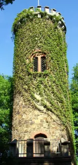 Ivy-covered stone tower with lush greenery under a bright blue sky.