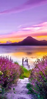 Purple sunset over lake with mountains and walking path.