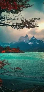 Scenic turquoise mountain lake with vibrant foliage under a moody sky.