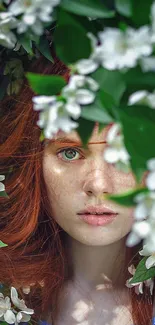 Woman with red hair surrounded by green leaves and white flowers.