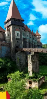 Hunedoara Castle under vibrant blue sky with lush greenery in Romania.