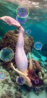 A mermaid swims gracefully by coral reefs in clear turquoise water.