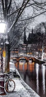 Winter canal scene with snow and streetlights reflecting on water.