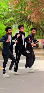 Three young men dancing energetically in a scenic park setting.