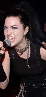 Woman passionately singing at a rock concert.