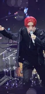 Energetic rock performer on stage with bright red hair and dynamic lighting.