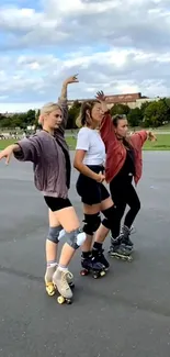 Three women roller skating energetically on a park road.