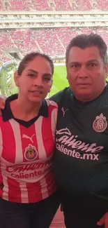 Fans in jerseys at a vibrant football stadium.