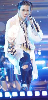 Performer on stage with blue lighting, wearing a white jacket.